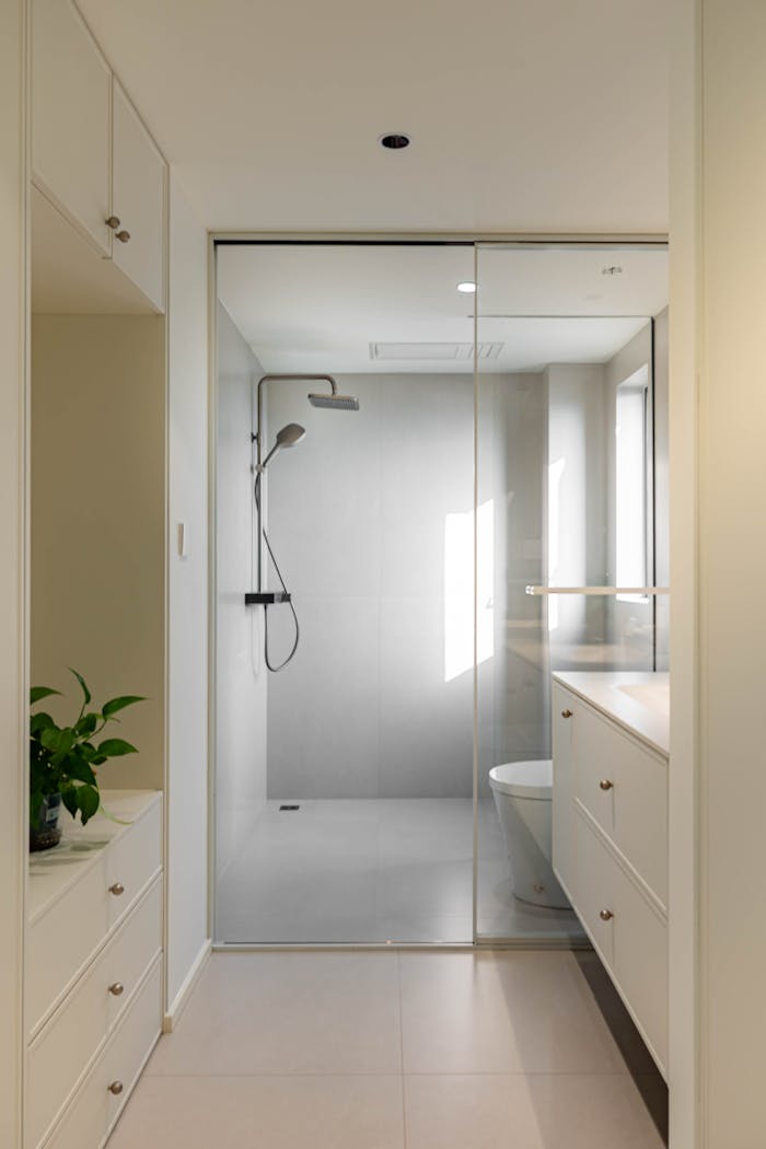 about-us-02 Bright and elegant modern bathroom with glass shower and sleek cabinetry.